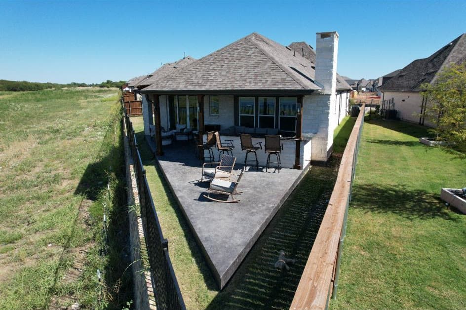 Aerial view of the same home with a new covered patio and outdoor furniture
